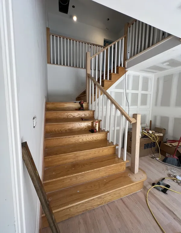 Finished oak staircase with wood railing and picture-frame wainscoting