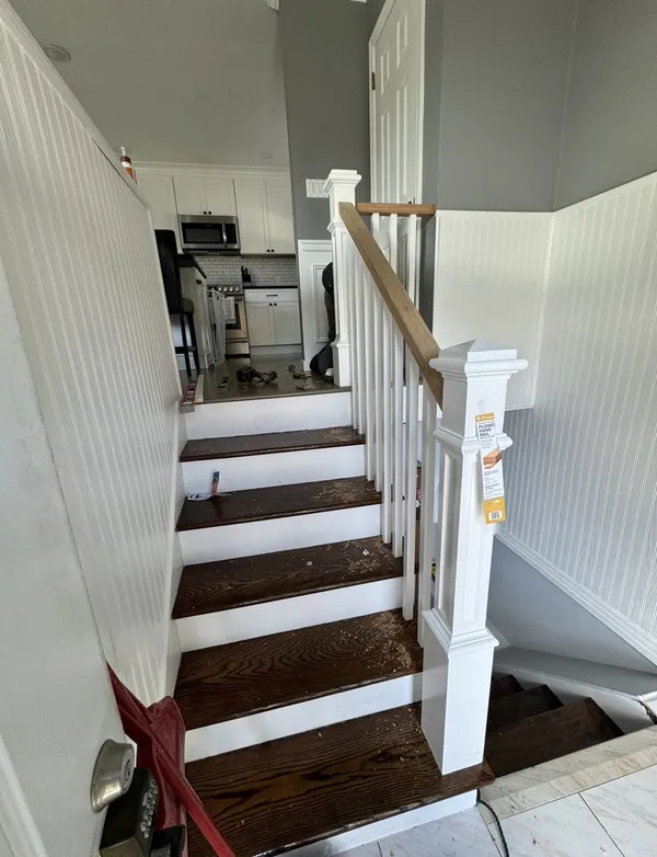 Dark-stained stair treads with white risers and a custom newel post