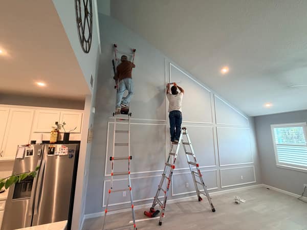 Craftsmen installing wainscoting trim
