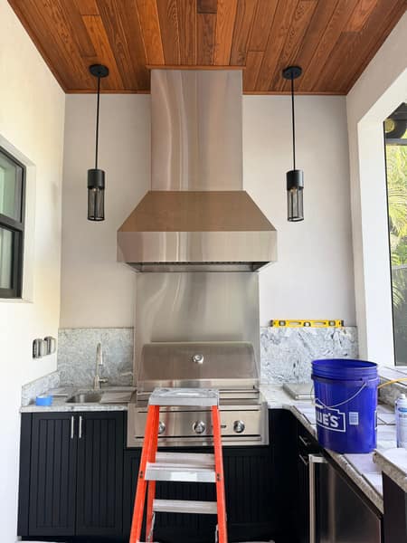 Outdoor kitchen build with stainless grill and vent hood