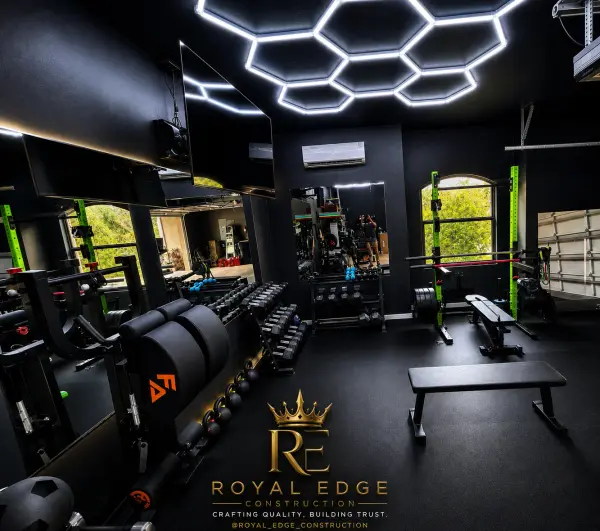Finished home gym with hexagon LED ceiling lights, dumbbell racks and weight bench